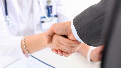 A physician and recruiter shaking hands during physician contract negotiating