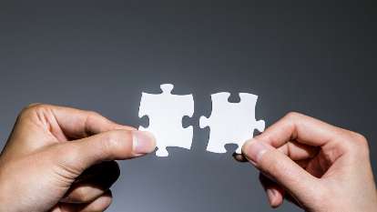 Two puzzle pieces being put together for physician contract negotiations