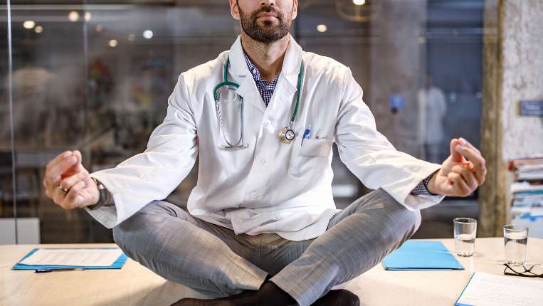 Promoting organizational wellness and culture; physician sitting and meditating